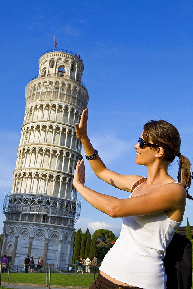 Young woman posing for photo with the Leaning Tower of Pisa, Pisa, UNESCO World Heritage Site, Tuscany, Italy, Europe