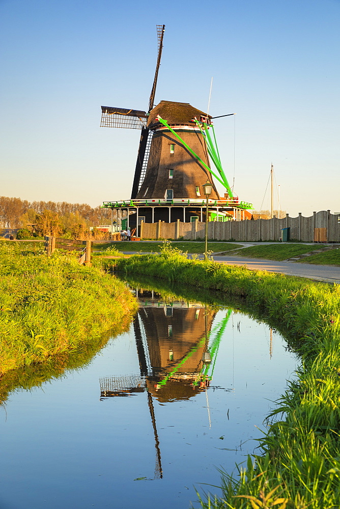 Windmill reflecting in a river, open-air museum, Zaanse Schans, Zaandam, North Holland, Netherlands, Europe