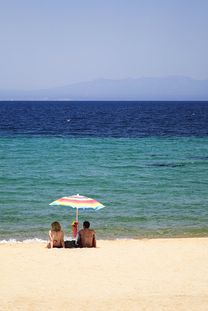 Couple under a parasol at the beach of Porto Puddu, Sardinia, Italy, Mediterranean, Europe 