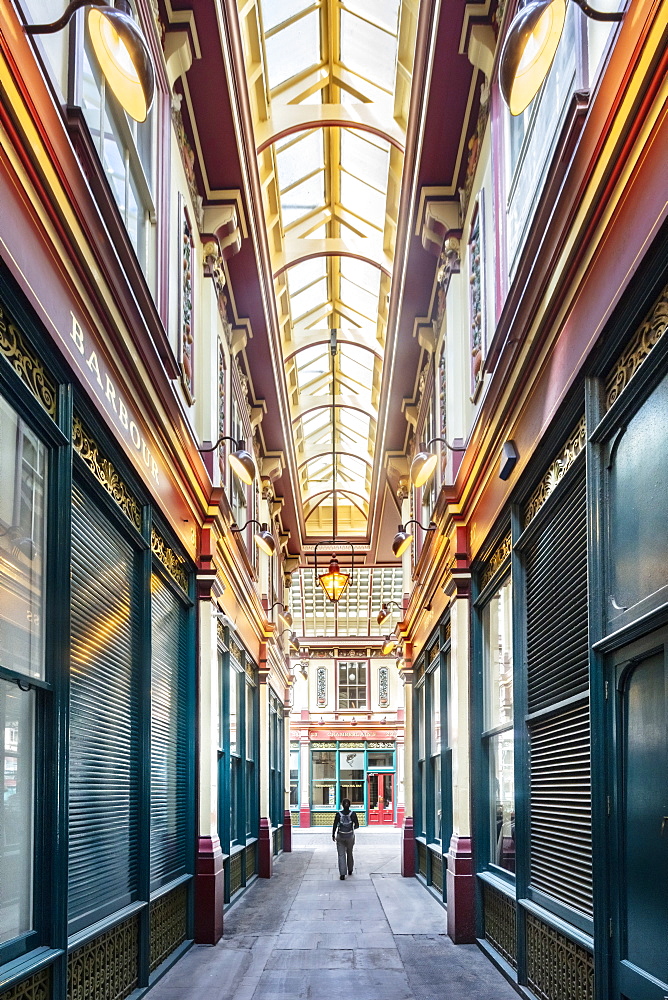 A woman walking through Leadenhall Market, a Victorian market designed by Horace Jones, City of London, London, England, United Kingdom, Europe