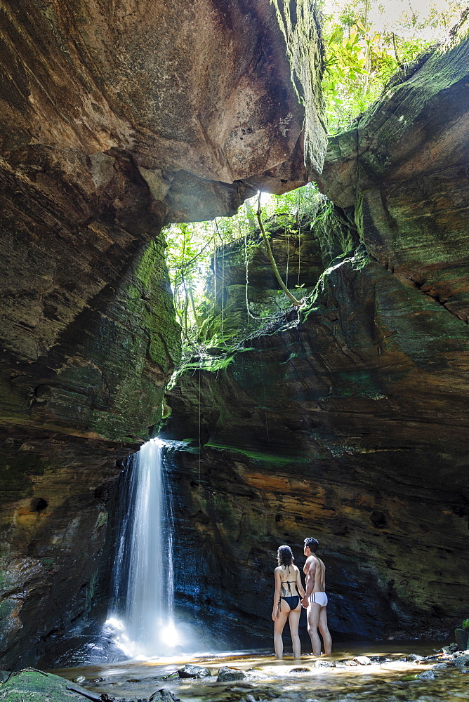 Backpackers enjoying a pristine waterfall and mountain stream in the heart of the South American rainforest, Minas Gerais, Brazil, South America