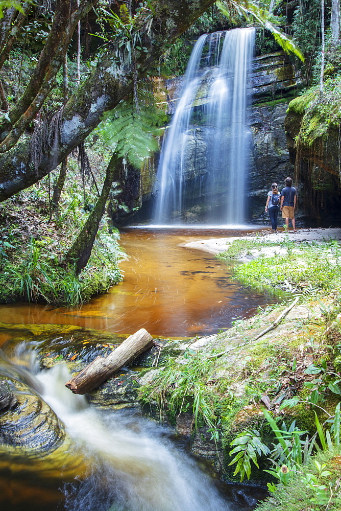 Backpackers enjoying a pristine waterfall and mountain stream in the heart of the South American rainforest, Minas Gerais, Brazil, South America