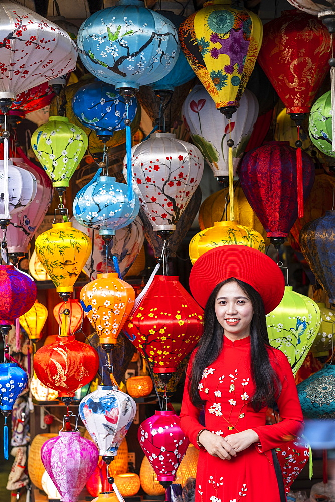 A young woman in traditional Vietnamese clothing standing outside a lantern shop, Hoi An, Vietnam, Indochina, Southeast Asia, Asia