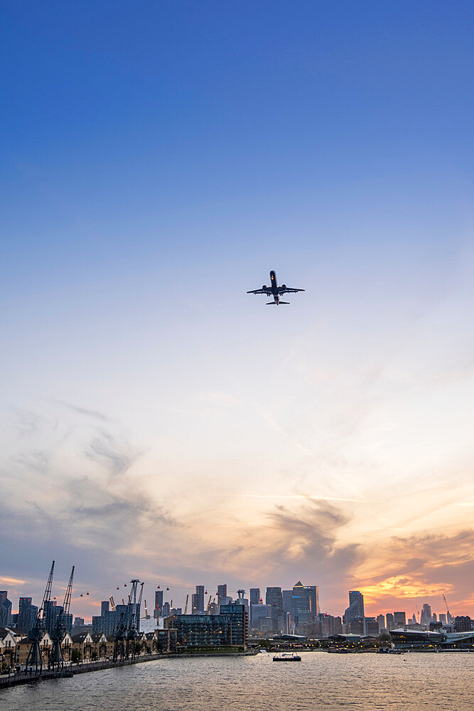 A plane arriving at the City of London airport with the Victoria Dock and skyline of the financial district, Docklands, London, England, United Kingdom, Europe