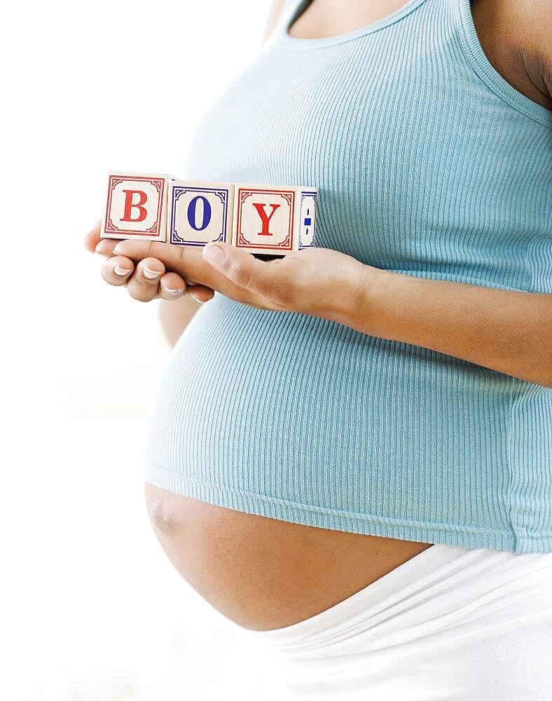 Pregnant African American woman holding 'BOY' blocks