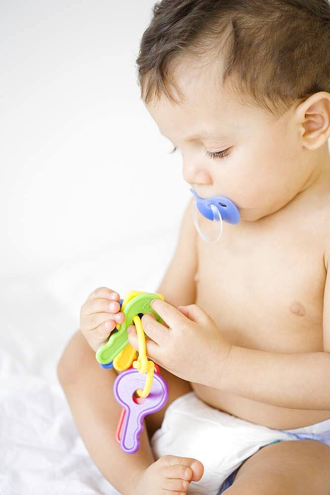 Hispanic baby playing with toy keys