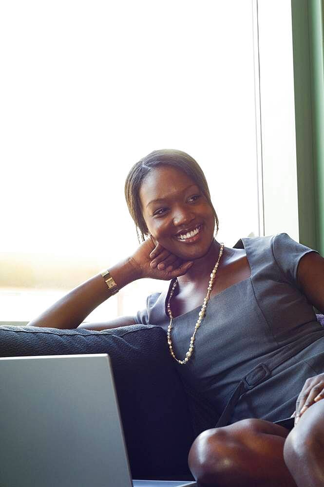 African businesswoman sitting on sofa