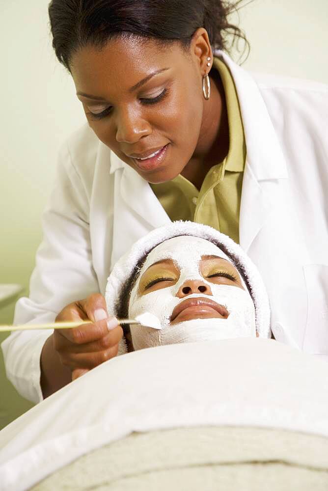 African woman receiving spa facial treatment