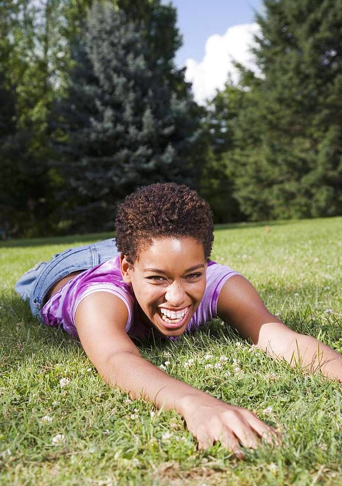 African American woman laying in grass