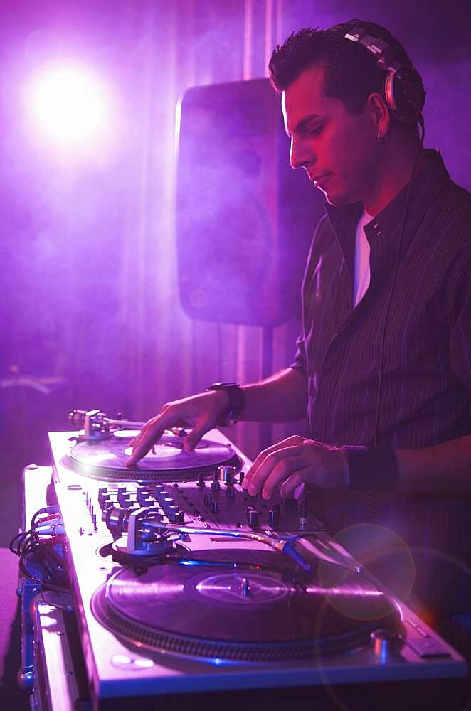 Hispanic dj playing at nightclub