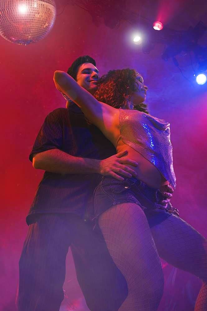 Multi-ethnic couple dancing at nightclub