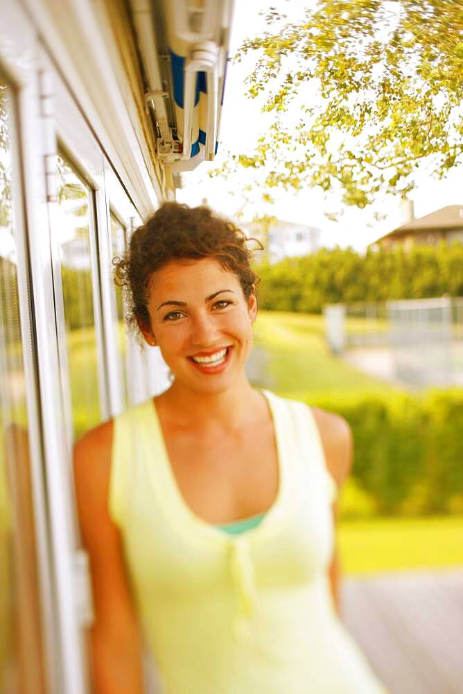 Young woman leaning against glass door