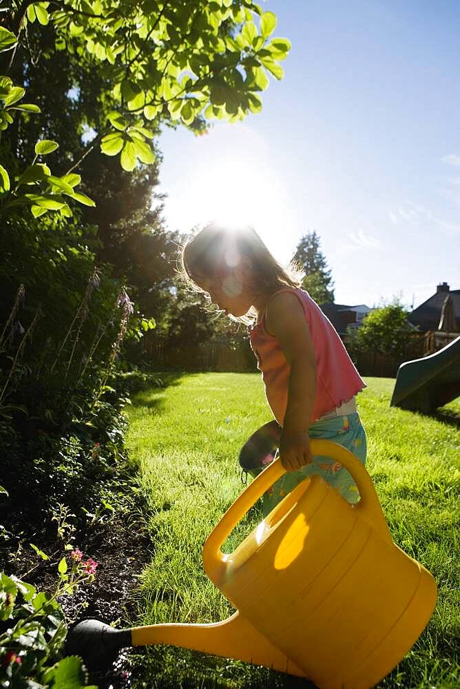 Girl watering plants with watering can