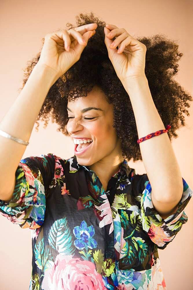 Laughing mixed race woman dancing