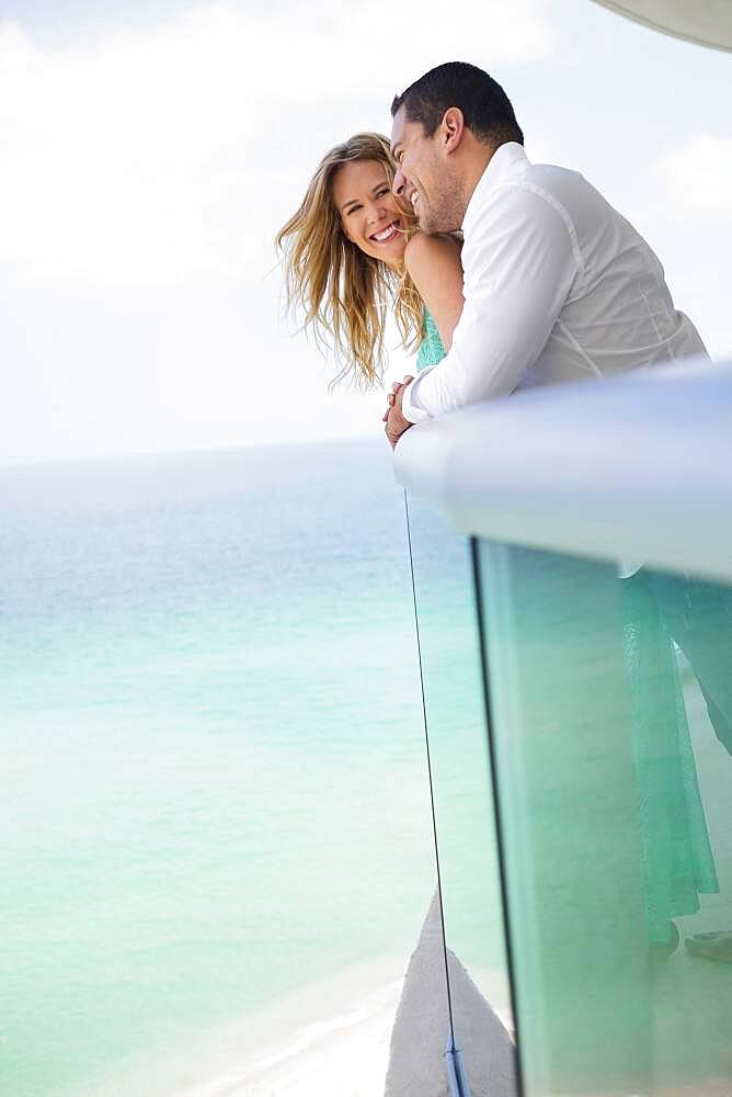 Couple hugging on balcony over ocean