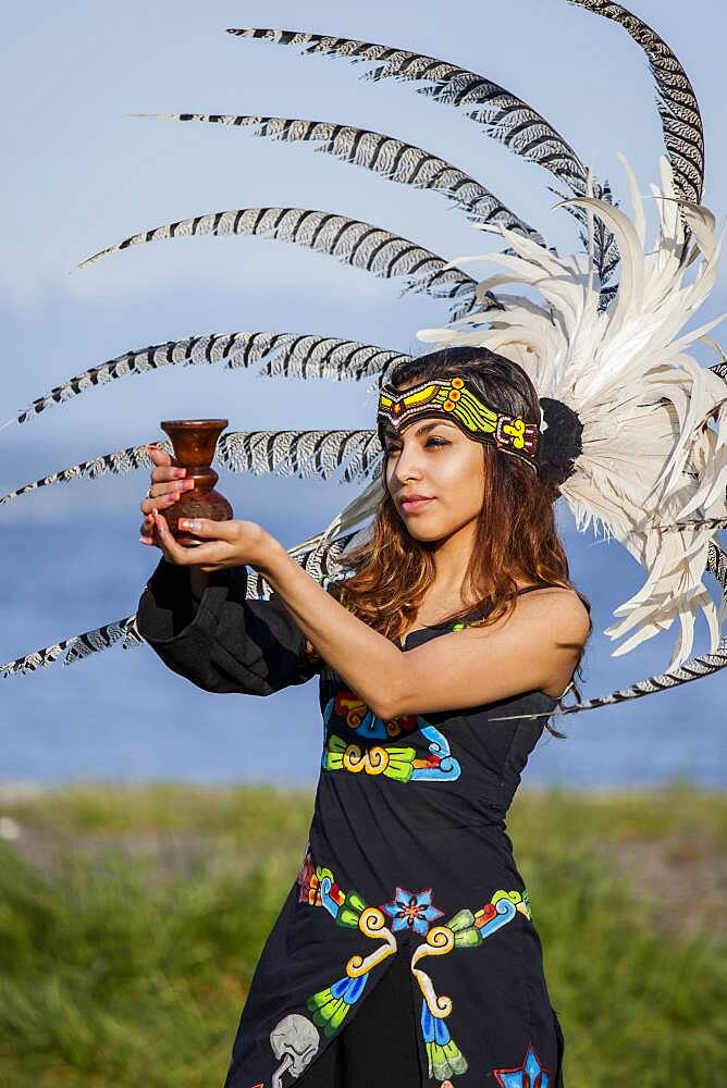 Native American woman in traditional headdress performing ceremony