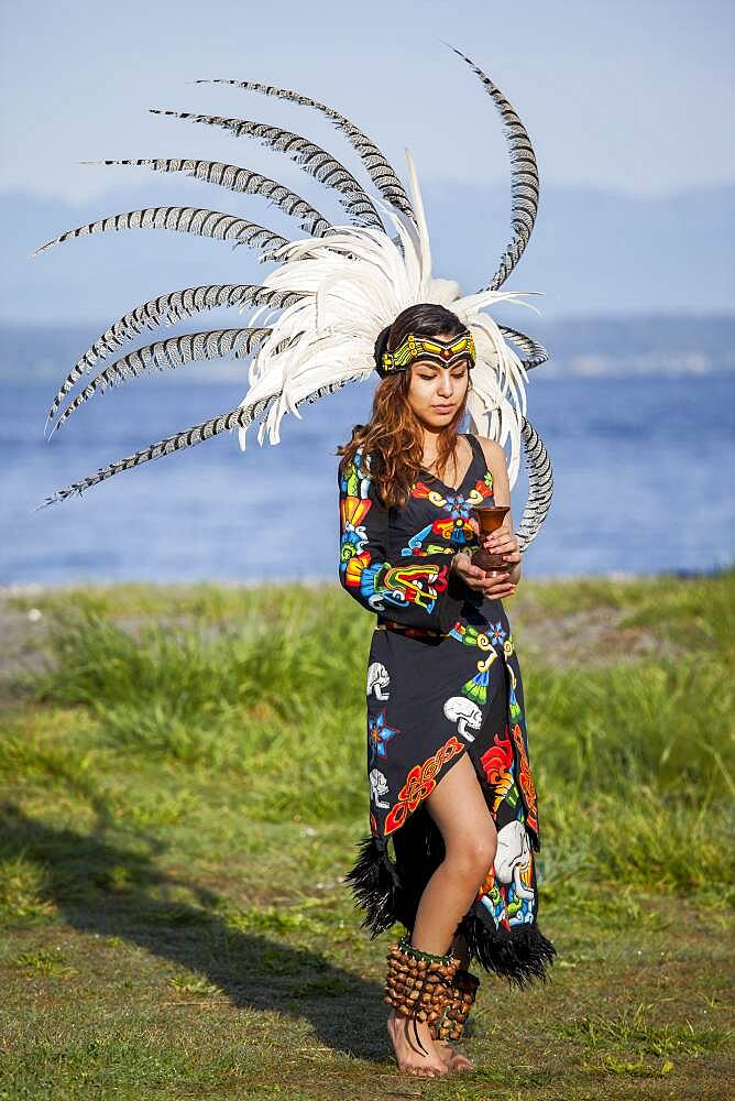 Native American woman in traditional headdress performing ceremony