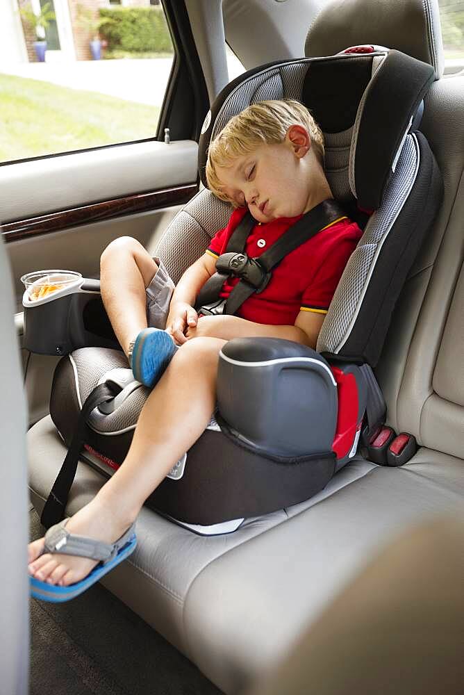 Caucasian boy napping in car seat