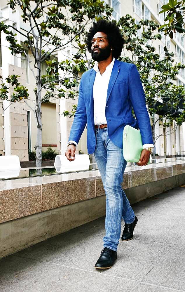 Mixed race businessman walking outdoors