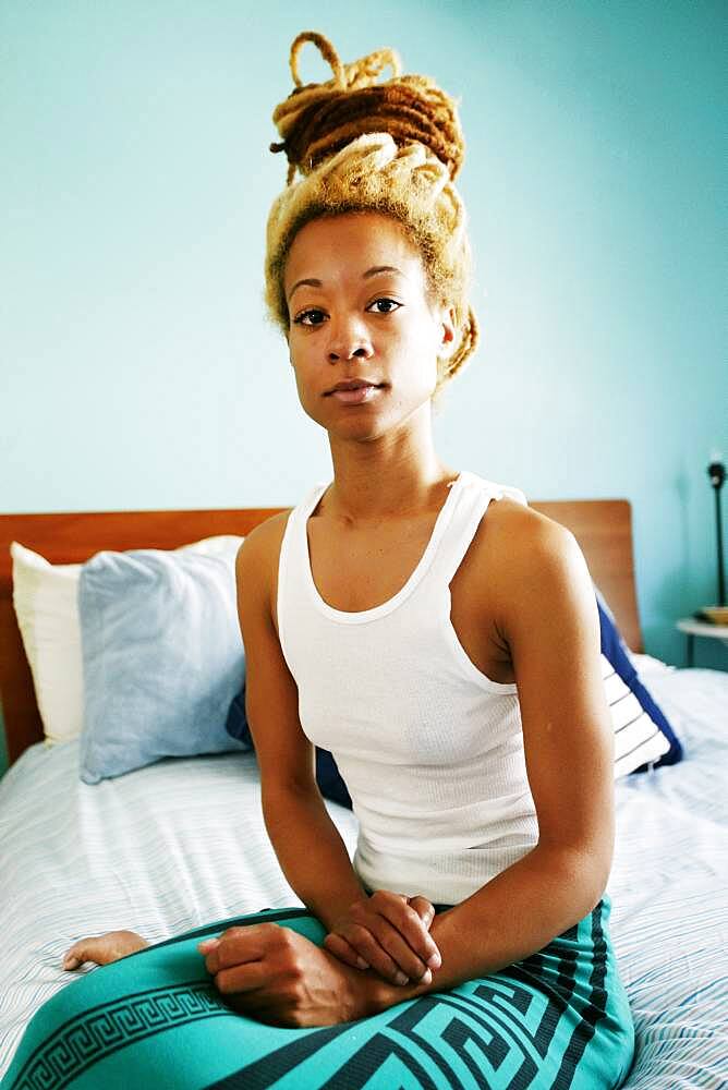 Black woman sitting on bed