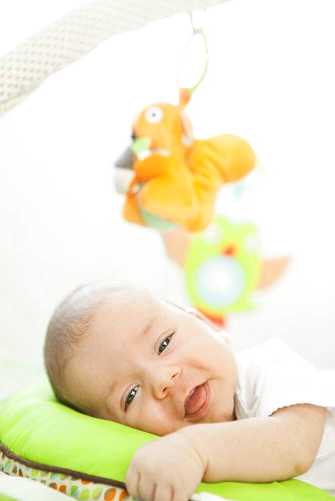 Mixed race baby laying on pillow