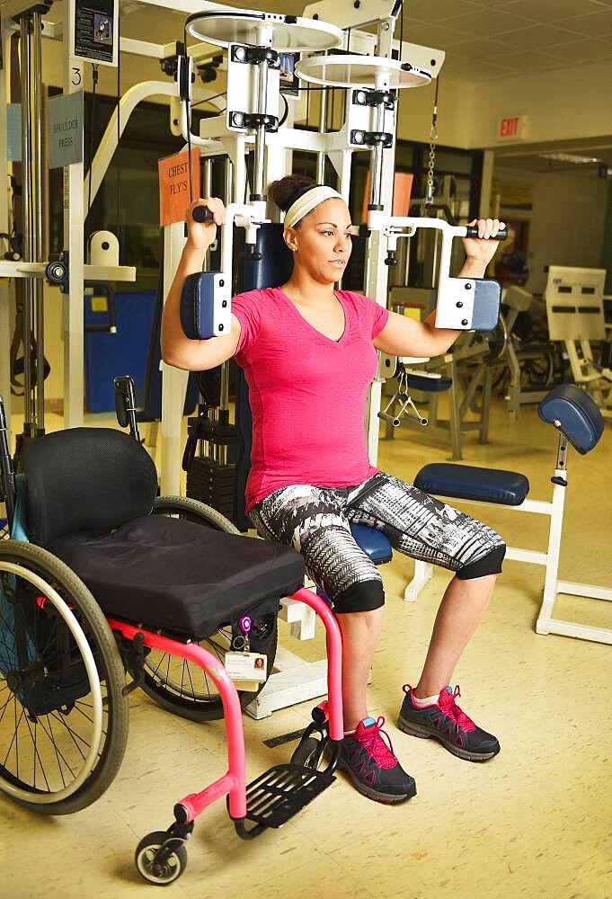 Paraplegic woman working out in physical therapy