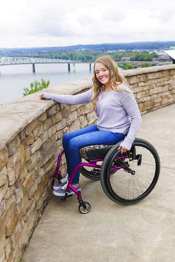 Caucasian disabled girl in wheelchair overlooking Columbus cityscape, Ohio, United States