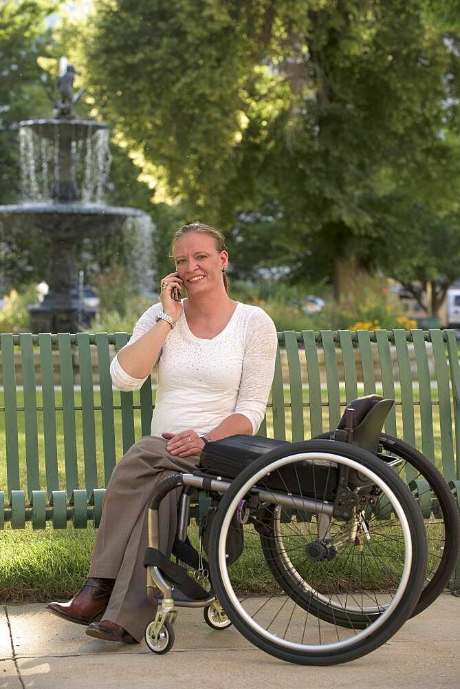 Disabled woman with wheelchair sitting on bench