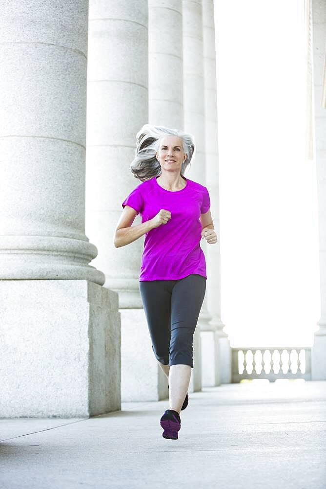 Caucasian woman jogging outside courthouse