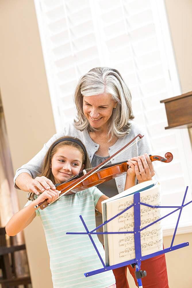 Caucasian woman giving student violin lessons