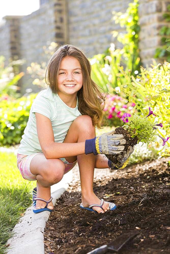 Caucasian girl planting seedling in backyard