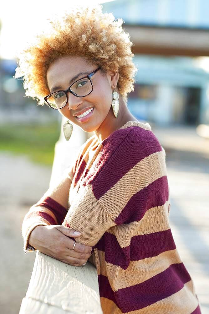 Black woman leaning on fence outdoors