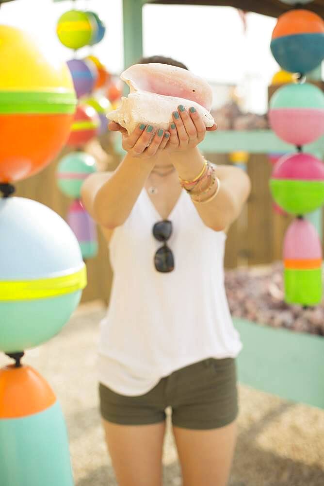 Caucasian woman holding conch shell