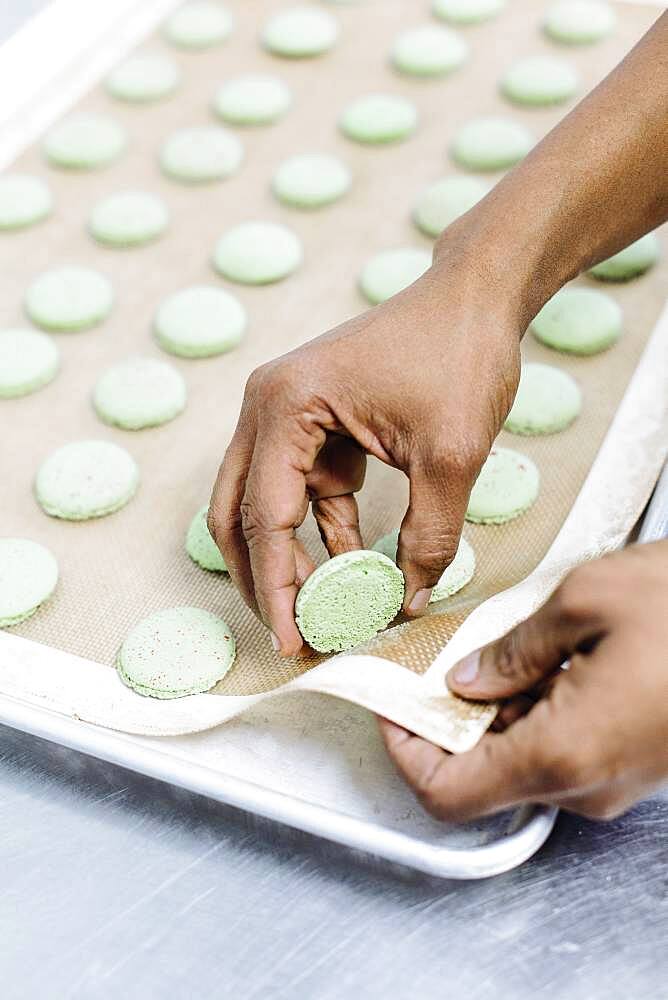 Close up of baker peeling cookies from tray