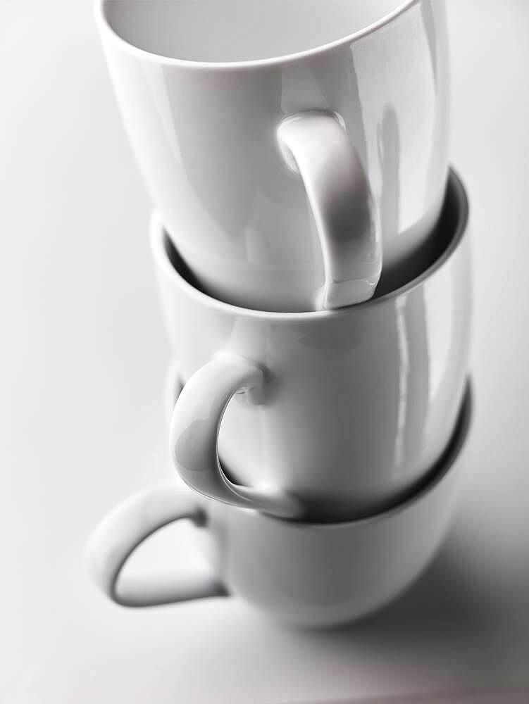 Close up of stacked white mugs