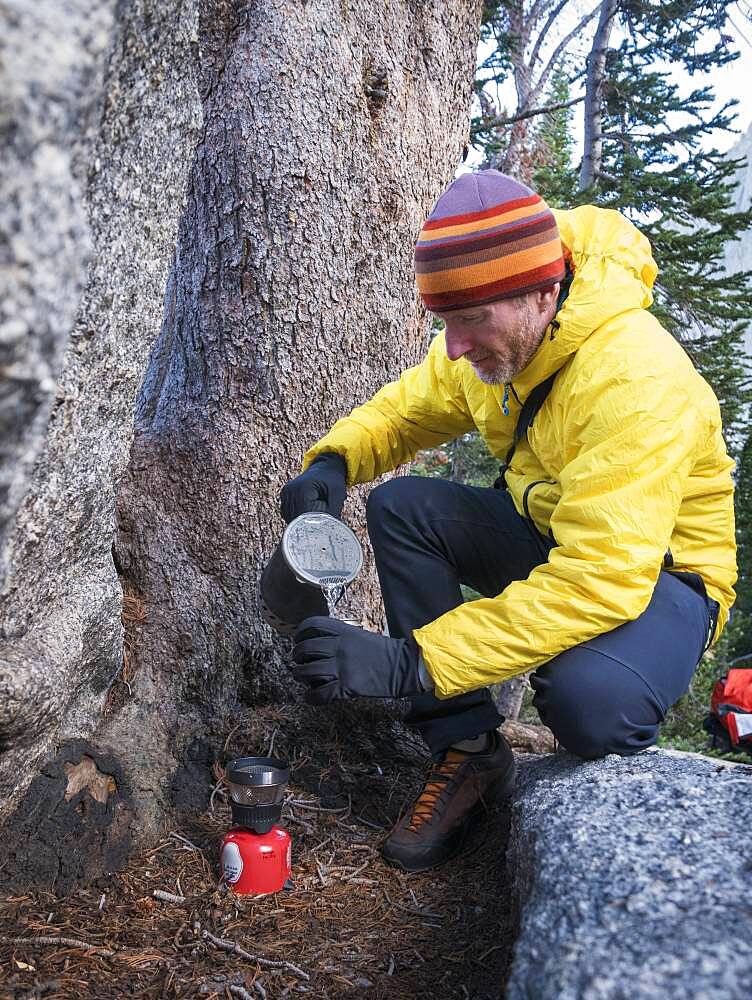 Caucasian hiker pouring coffee outdoors