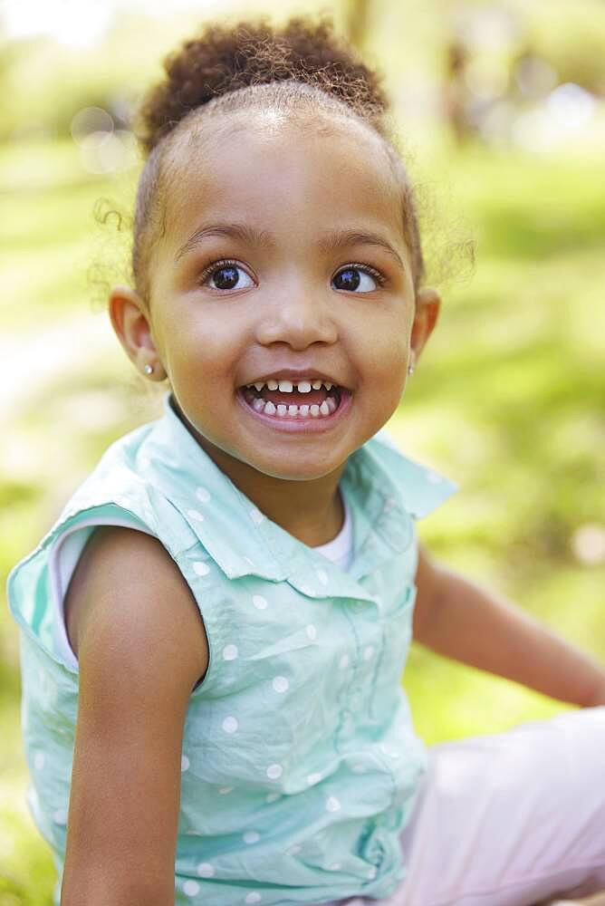 Mixed race girl smiling in park