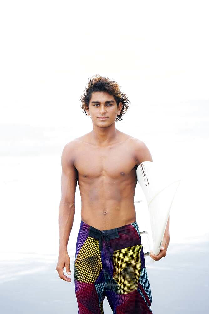 Man carrying surfboard on beach