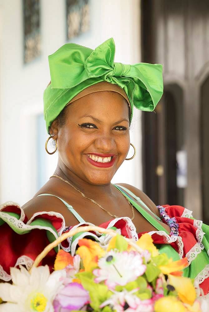 Hispanic woman carrying basket of flowers