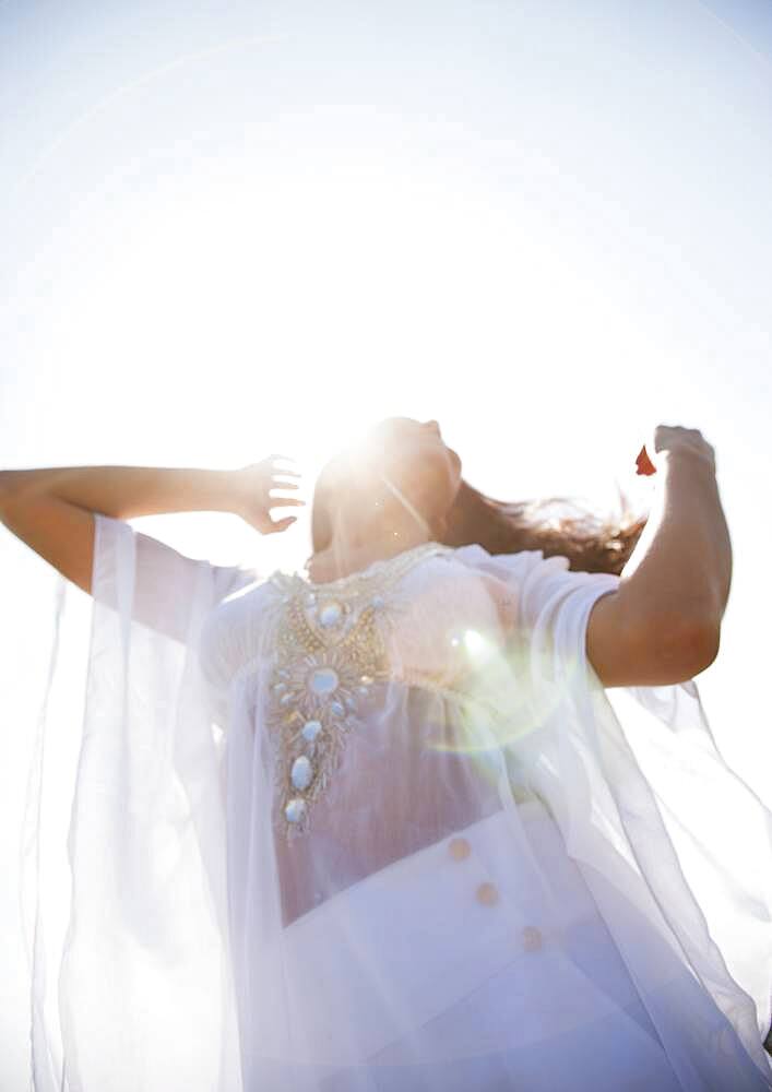 Hispanic woman standing under blue sky