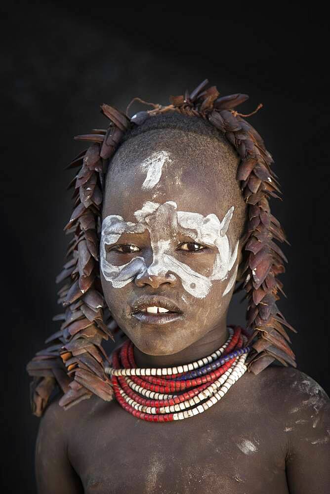 Black teenage girl wearing traditional face paint