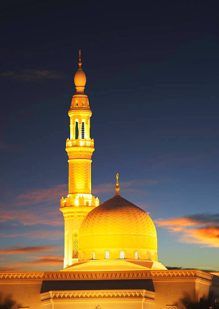 Illuminated pillar and dome under sunset sky