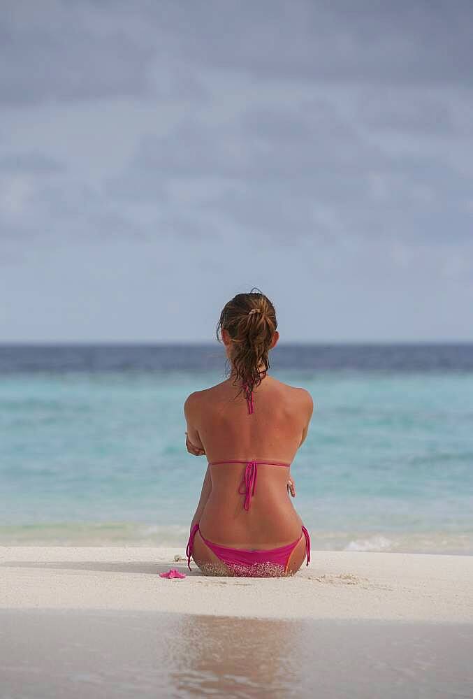 Caucasian woman sitting on beach