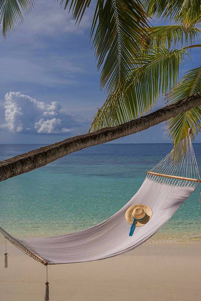 Sun hat in empty hammock on beach