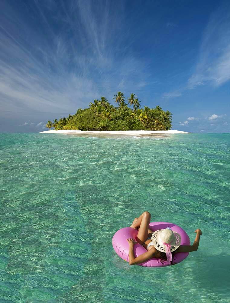 Caucasian woman floating near tropical island