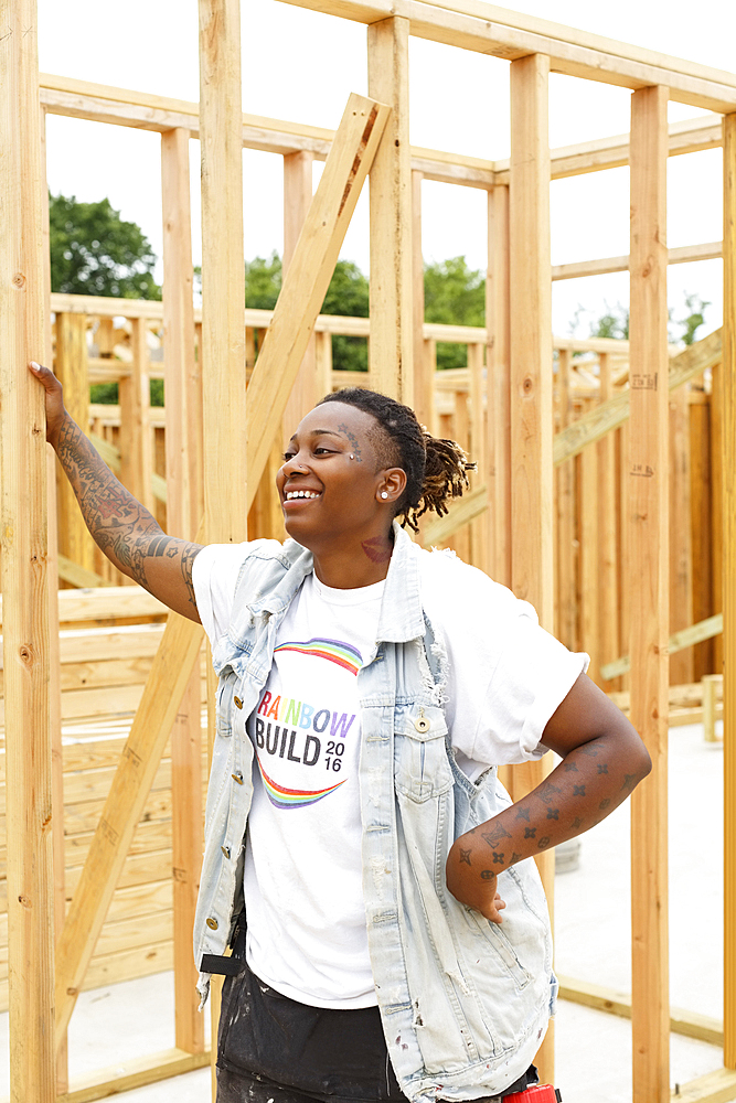 Mixed race man leaning on lumber at construction site