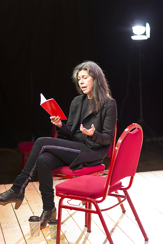 Hispanic woman reading script on theater stage