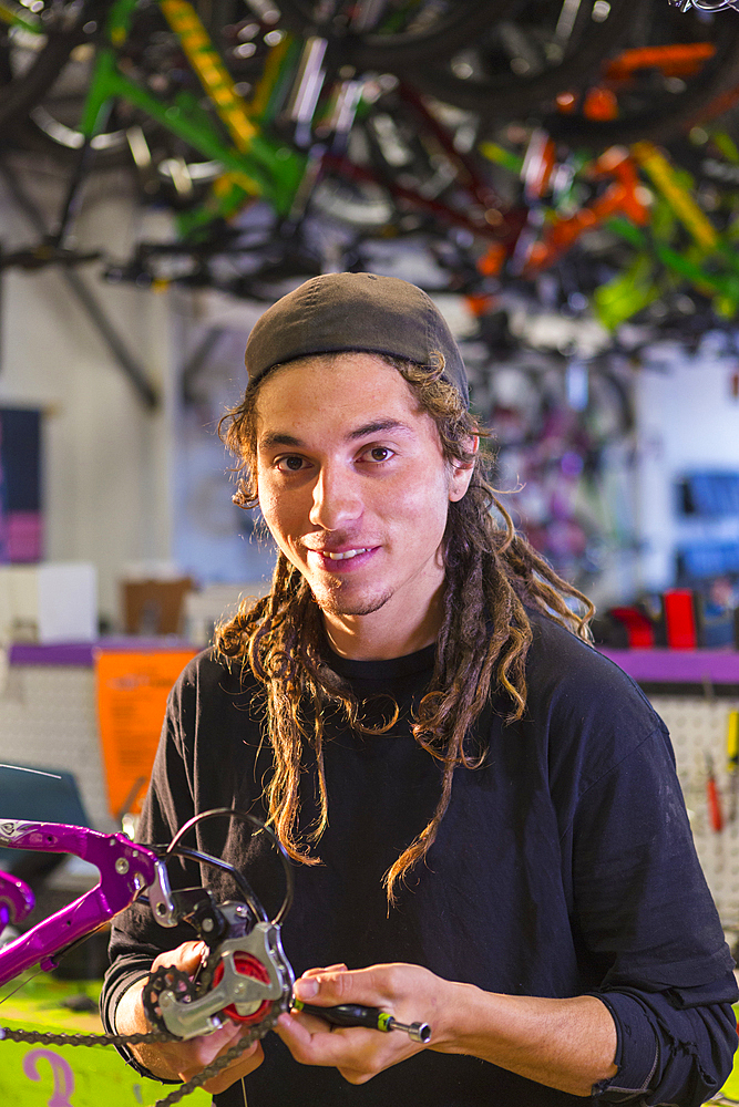 Portrait of smiling man repairing bicycle in shop