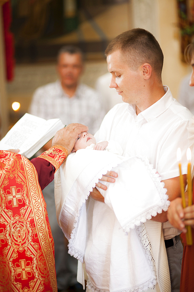 Priest blessing baby boy in church