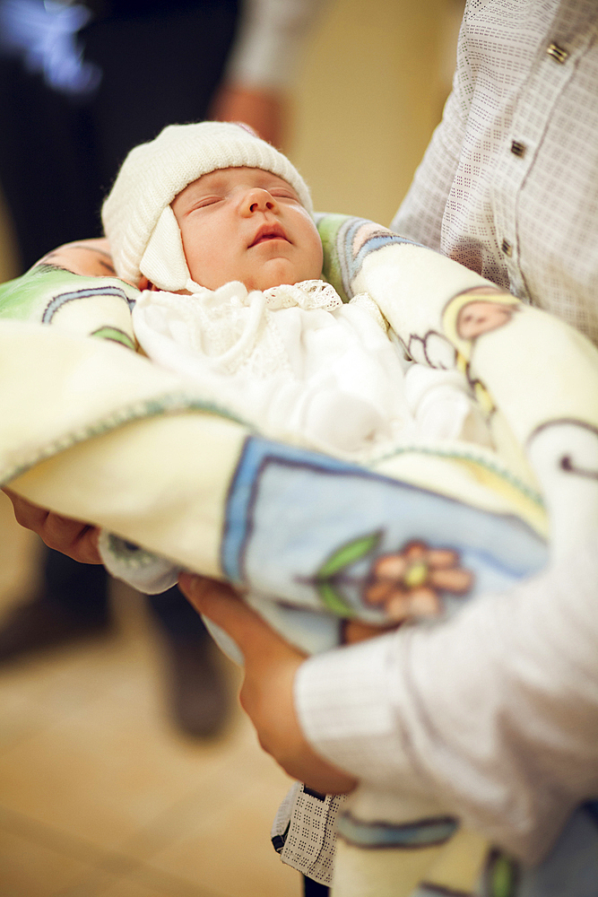 Man carrying a baby girl in blanket